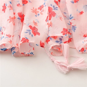 Detail of pink floral scarf with delicate tassels and breathable cotton-linen texture