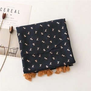 Detail of dark blue scarf with golden horse patterns and brown decorative fringe