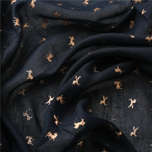 Detail of dark blue lightweight scarf with golden unicorn foil print and texture