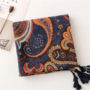Detail of dark blue paisley scarf with tassels and light cotton linen texture