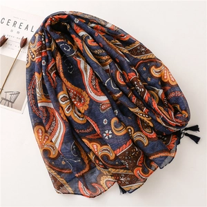 Detailed macro view of vintage paisley patterns and soft tassels on the navy cotton scarf
