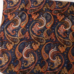 Detailed view of lightweight navy blue scarf with orange and brown paisley pattern fabric