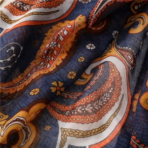 Close-up of lightweight paisley cotton-linen scarf with intricate dark blue and orange patterns