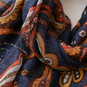 Detailed close-up of dark blue paisley print scarf with textured cotton-linen feel fabric