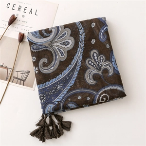 Close-up of deep brown paisley scarf with blue patterns and soft fringe detail