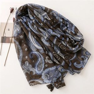 Detailed macro view of dark paisley cotton scarf with soft fringe and floral patterns