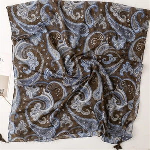 Detailed macro view of paisley pattern on lightweight scarf with tassel fringe edges