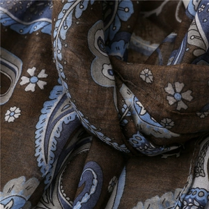 Detailed macro view of soft dark brown paisley cotton linen scarf with blue flower pattern