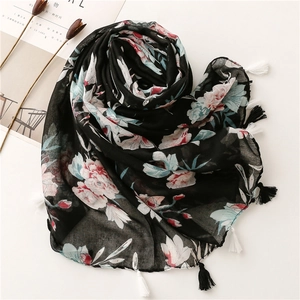 Detail of floral Bali yarn scarf featuring pink blossom patterns and long black tassels