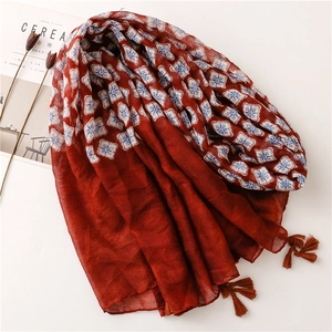 Écharpe rouge foncé en coton et lin avec motifs floraux bleus et finitions à franges