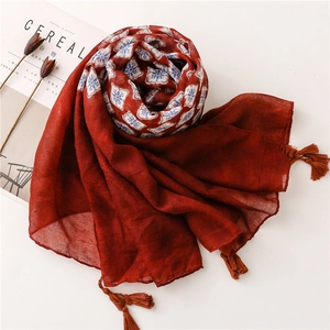Détail de l'écharpe en coton rouge brique avec franges et doublure à motif ethnique