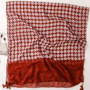 Détail d'une écharpe rouge à imprimé géométrique avec franges boho et texture coton-lin