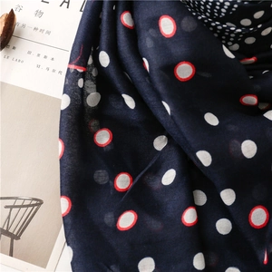 Detail of navy blue cotton scarf featuring white polka dot pattern and soft fringe edges