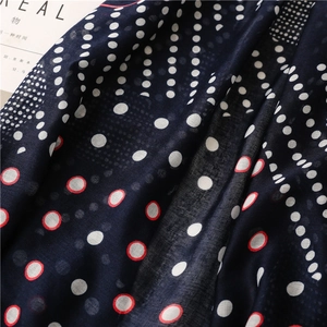 Close-up of navy cotton linen scarf featuring white polka dots and textured fabric