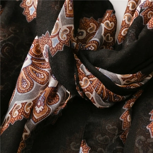 Détail macro du motif paisley bohème sur tissu en coton et lin noir avec plis souples