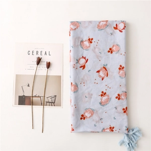 Écharpe en coton et lin bleu clair avec imprimé floral et glands pour la plage