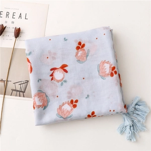 Détail de l'écharpe florale bleu clair avec bords à glands et tissu aspect lin