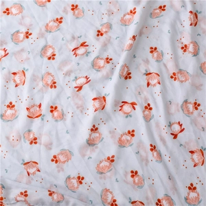 Détail du motif floral avec des protéas roses et oranges sur un tissu en coton blanc pur