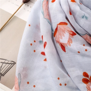 Gros plan détaillé de l'écharpe en coton et lin bleu clair à motifs floraux doux
