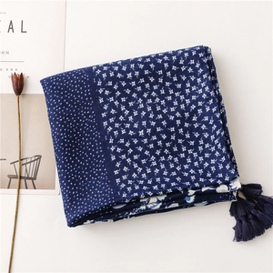 Close-up of navy cotton linen scarf with white floral patterns and fringe details