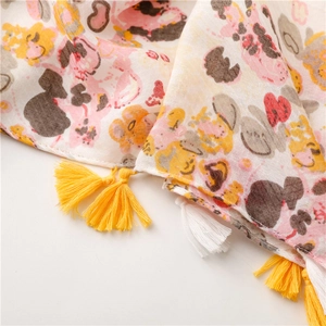 Detail of floral print scarf showing soft fabric texture and yellow tassel fringe edge