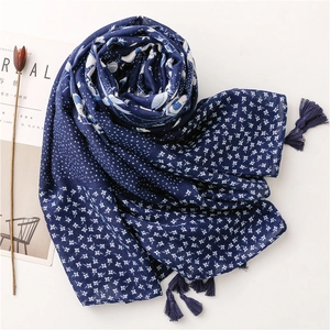 Detail of navy blue cotton linen shawl featuring white floral dots and cotton tassels