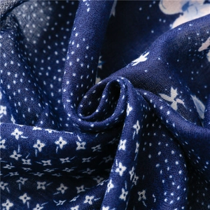 Blue cotton linen scarf with white floral patterns and tassel trim details