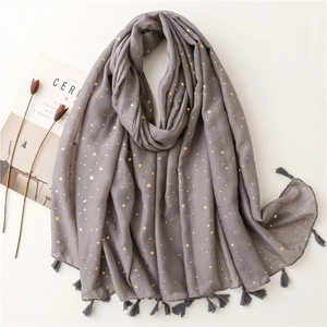Macro detail of gold moon and star prints on grey cotton feel scarf with tassels