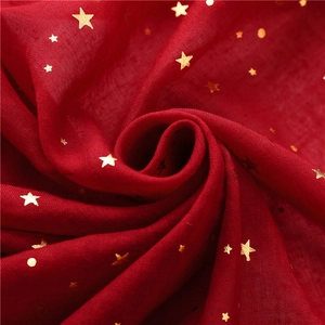 Macro shot of dark red cotton linen scarf featuring gold foil star and moon patterns