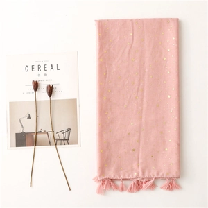 Detail of pink cotton scarf featuring gold foil star and moon patterns with elegant fringe