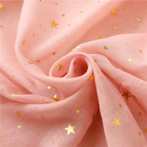Close-up of pink bali yarn scarf featuring gold foil star and moon patterns with fringe