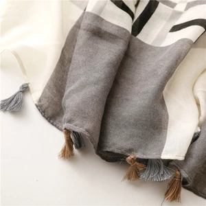 Detailed macro view showing the linen-texture weave and classic plaid fringe of the scarf