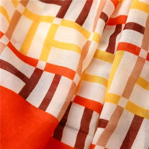 Close-up of lightweight plaid scarf fabric with orange and yellow grid weave texture