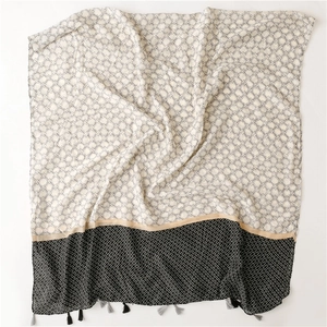 Detail of soft geometric star pattern scarf with black and grey fringe tassels
