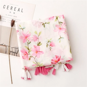 Detail of pink floral cotton scarf with handmade tassels and minimalist magazine styling