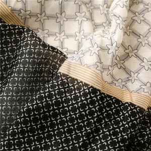 Close-up of geometric star pattern scarf with soft cotton-linen texture and piped edges