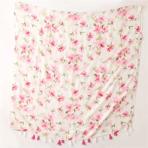 Close-up of pink floral prints and delicate dual-tone tassels on a white cotton shawl