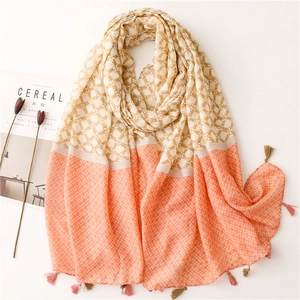 Detail of two-tone scarf featuring floral patterns, geometric prints and tassel accents