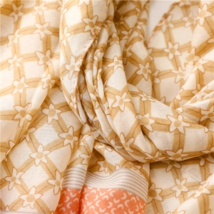 Detail of soft cotton linen scarf with floral grid pattern and geometric border finish