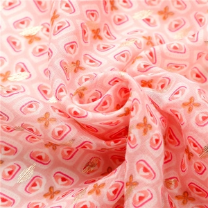 Macro view of light pink cotton-linen scarf with geometric gold foil prints and heart patterns