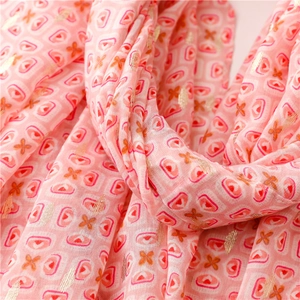 Detailed close-up of pink geometric pattern scarf with elegant gold foil star accents