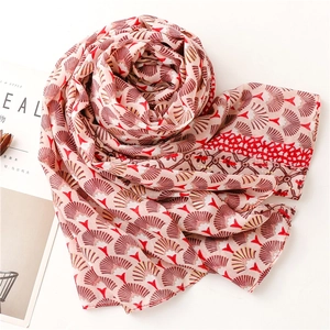 Détail d'une écharpe rose en coton-lin avec motifs botaniques en éventail rouges et dorés