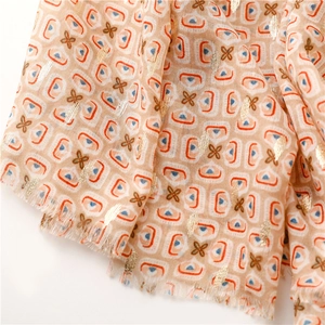 Detail of soft peach cotton linen scarf with geometric patterns and gold foil dots