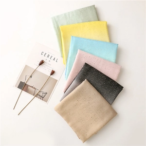 Detailed view of lightweight scarves with gold foil dots in multiple gradient colors