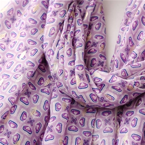Close-up of purple geometric print scarf with gold foil accents and soft cotton-linen texture
