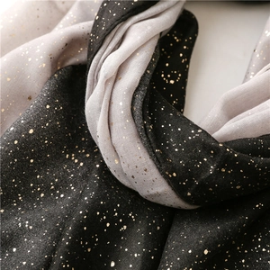 Detailed macro shot of bicolor scarf fabric with gold foil dots and soft texture