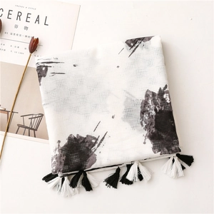 Detail of artistic ink print cotton scarf with handcrafted fringe and linen texture