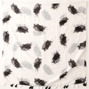 Detail shot of abstract black ink print and dual-tone fringe tassels on linen-feel scarf
