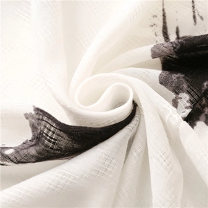 Detail of soft cotton linen scarf showing black hand-painted prints and fabric texture