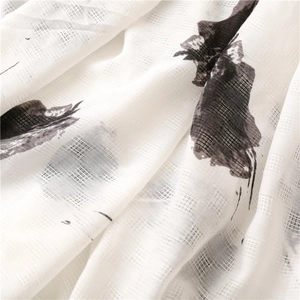 Detailed close-up of white linen-feel fabric with black artistic hand-painted ink prints